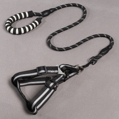 Black and white dog harness and leash set on a gray background