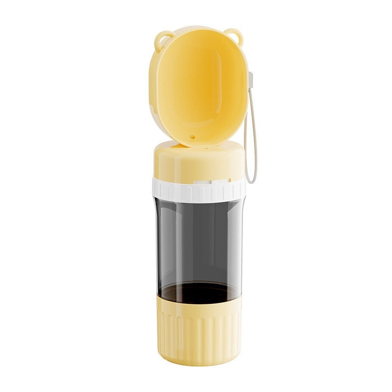 Dog drinking from portable dog water bottle dispenser outdoors